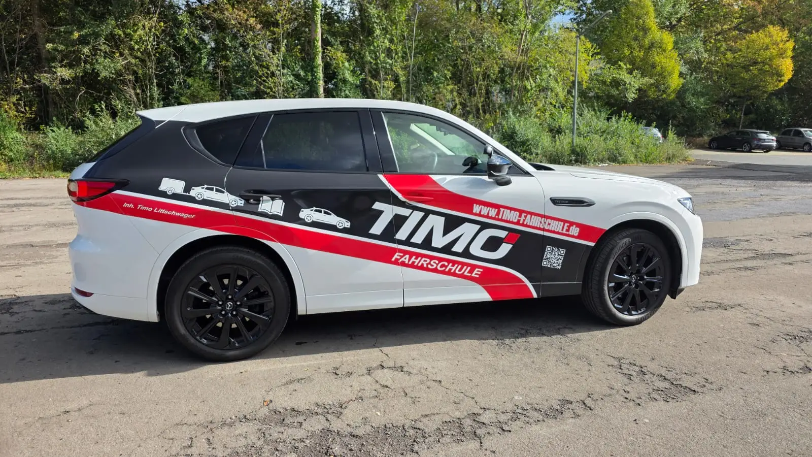 Mazda CX-60 der Timo Fahrschule mit gut sichtbarer Fahrzeugbeschriftung in der Seitenansicht